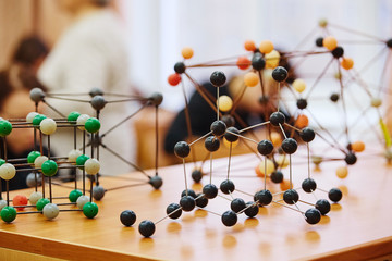 Students sit in the classroom and listen to a lecture in science. Plastic molecular educational...