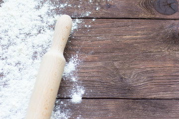 white wheat flour and rolling pin on wooden background