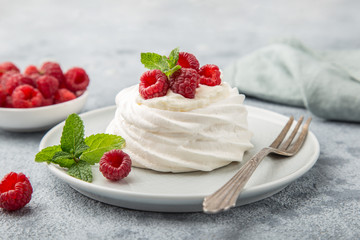 mini pavlova  meringue cakes with whipped cream and fresh raspberry