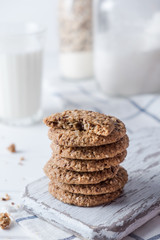 Close up of baked wholegrain cookies on white wooden table with milk on background