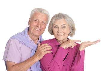 Portrait of happy senior couple showing something on white background