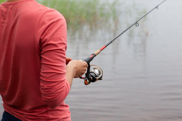 Fishing rod with a fishing reel in a woman's hand