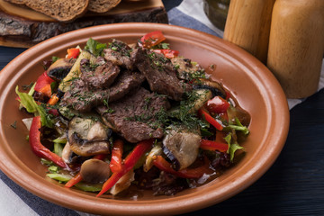 Grilled  veal  garnished with vegetables. Meat salad on a plate