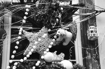 Christmas decoration with white bears, red hearts, stars, and snowflakes in medieval city of Strasbourg (France) which is considered as a Capital of Christmas. Closeup. Black and white photo.