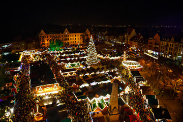 Naklejka premium Traditional Christmas market in Erfurt, Thuringia in Germany. With xmas tree, pyramide and sales and food stands on late evening or night.