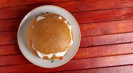 Bread with sausage, cheese and sour cream on a plate on the table. The view from the top.