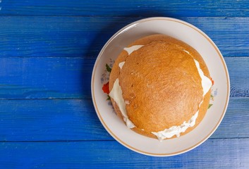 Bread with sausage, cheese and sour cream on a plate on the table. The view from the top.