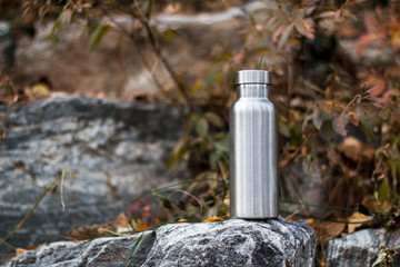 Obraz premium Insulated Stainless Bottle on the stone steps in the forest