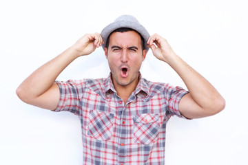 Naklejka premium surprised latin man with hat and open mouth against isolated white background