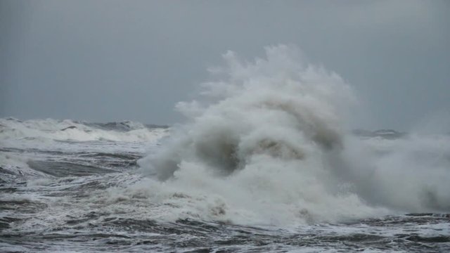 High wave breaking on the rocks of the coastline. Extremely Big Wave crushing coast , Large Ocean Beautiful Wave. Super Slow Motion..