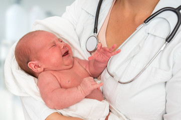 Pediatrician doctor is holding newborn baby in arms © andriano_cz