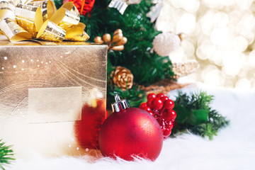 gift box and ball decoration under christmas tree on white fer with gold bokeh light background