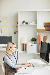 Content concentrated attractive woman sitting at desk with powerful computer and coding information for software