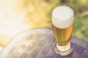 Glass of beer on a table and with room for text on the side.