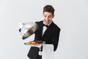 Portrait of a handsome young waiter in tuxedo