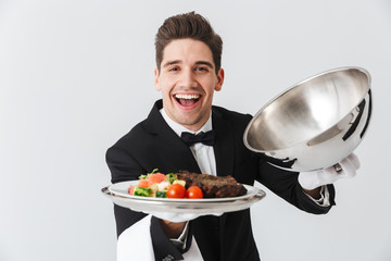 Portrait of a handsome young waiter in tuxedo