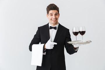 Portrait of a smiling young waiter in tuxedo