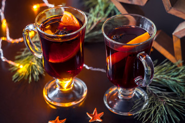 Festive mulled wine on the snow.Holiday decorations, pine twigs.