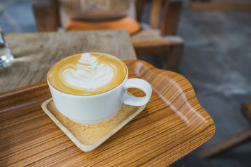 A Cup of hot latte art coffee on wooden table