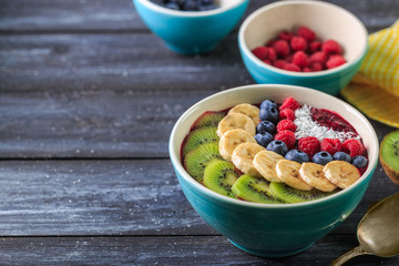 Healthy breakfast with delicious acai smoothie in bowl on dark background