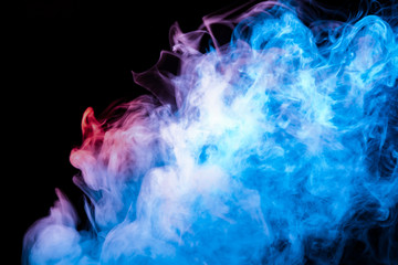 Multicolored pattern of the smoke of the blue and red colors of the mystical shape on a black isolated background. Abstract pattern in the form of waves and steam.
