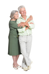 Portrait of beautiful senior couple hugging on white background