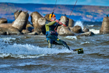 A male kiter slides on the surface of the water. Splashes of water fly apart. Close-up.