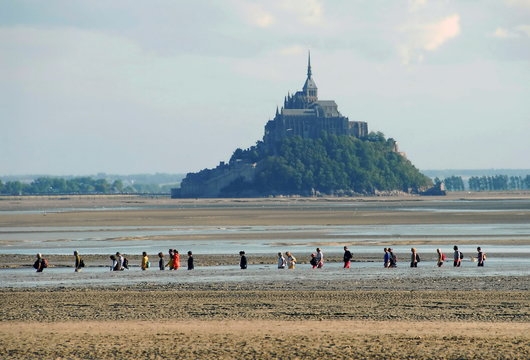Groupe de personnes traversant la baie du Mont-Saint-Michel à marée basse, département de la Manche, Normandie, France