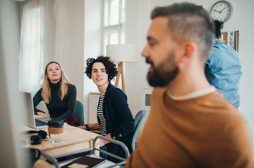 Group of young businesspeople with laptop working together in a modern office.