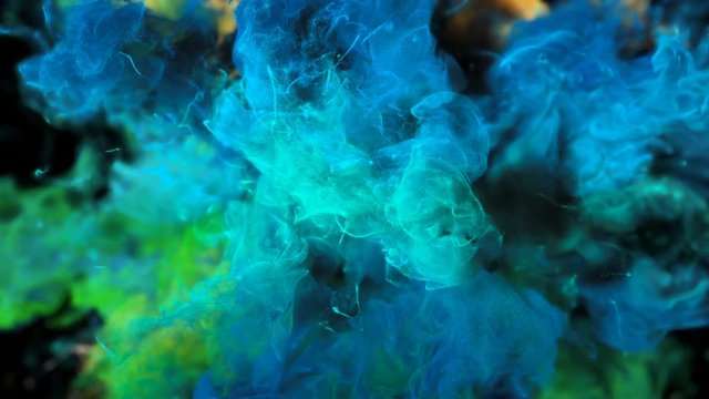 Color Burst - colorful blue green yellow smoke explosion fluid gas ink particles slow motion alpha matte isolated on black macro close-up