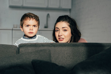 portrait of mother and little son sitting on sofa at home