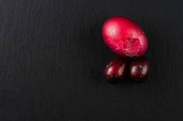 one red easter egg and two quail eggs