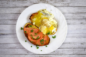 Crispy toast, scrambled eggs and tomatoes on a white plate for Breakfast.