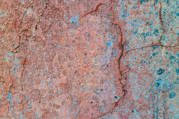 an old painted wall with pealing blue and orange paint
