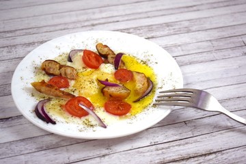 Delicious scrambled eggs with tomatoes and sausages for Breakfast.