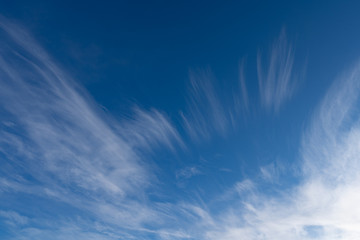 blue sky with light feather clouds