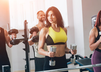 Fototapeta premium Group of athletic young peoples making exercise at the gym. Young men and women with muscular body.