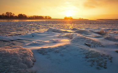 Winter landscape with frozen lake and sunset fiery sky. Composition of nature.