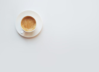 Fototapeta na wymiar Cup of coffee - top view minimalist composition on a white background. White mug with espresso, flatlay