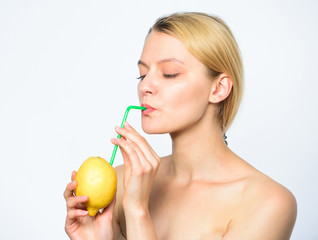 Woman enjoy vitamin beverage. Healthy lifestyle and organic nutrition concept. Benefits of drinking lemon water in morning empty stomach. Girl drink fresh juice whole lemon fruit with cocktail straw