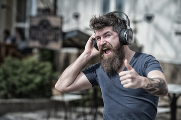 Man bearded hipster with headphones listening music. Hipster enjoy high quality sound of song in...
