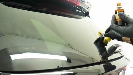 Professional Car Ceramics Worker applies a layer of ceramics (protective rain cover) on car windows. Concept from: Nano Protection, Different accessories, Long protection.