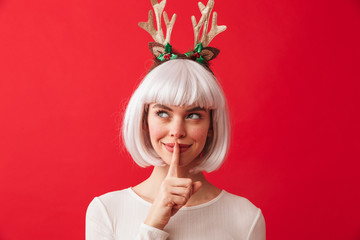 Cute woman isolated over red wall background wearing deer ears costume carnival showing silence gesture.