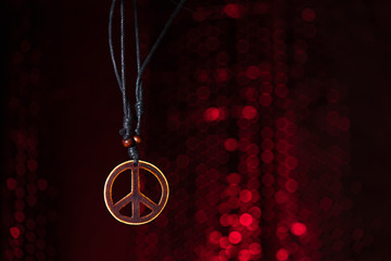 Wooden peace symbol with red lights background