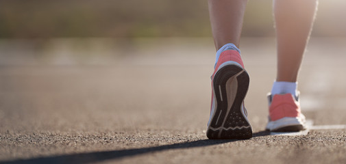 Running shoe closeup of woman running on road with sports shoes - obrazy, fototapety, plakaty