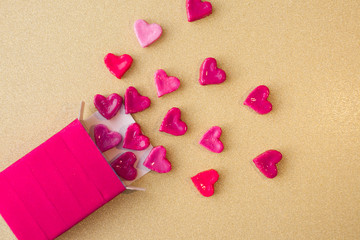 Fototapeta premium Valentine's day concept. gift for Valentine's Day, a red box with sweet hearts on a gold background. Pictures of Love. selective focus