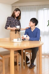 Obraz premium コーヒーを飲むながら語らう若い夫婦