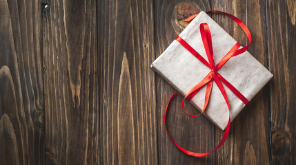 gift with red ribbon on the wooden table