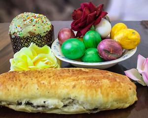 Sweet Easter cakes with colorful eggs on table in room