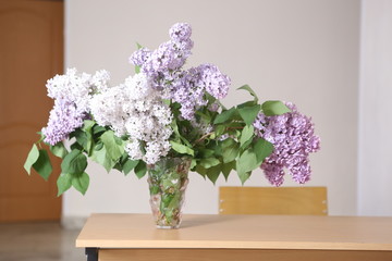 lilac flowers close up photo in vase on table